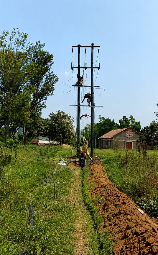 TES engineers installing a power line in rural Uganda